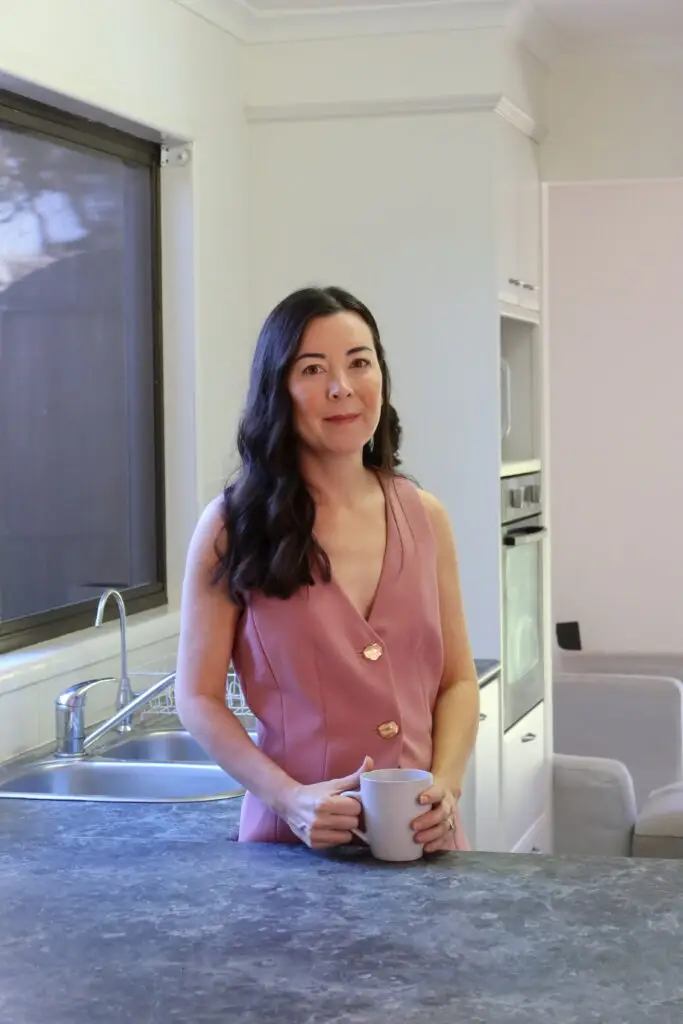 Tracy at home in her kitchen holding a mug