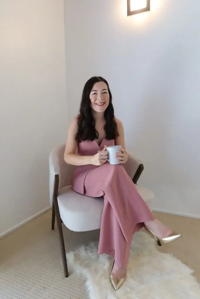 Tracy seated, holding a mug