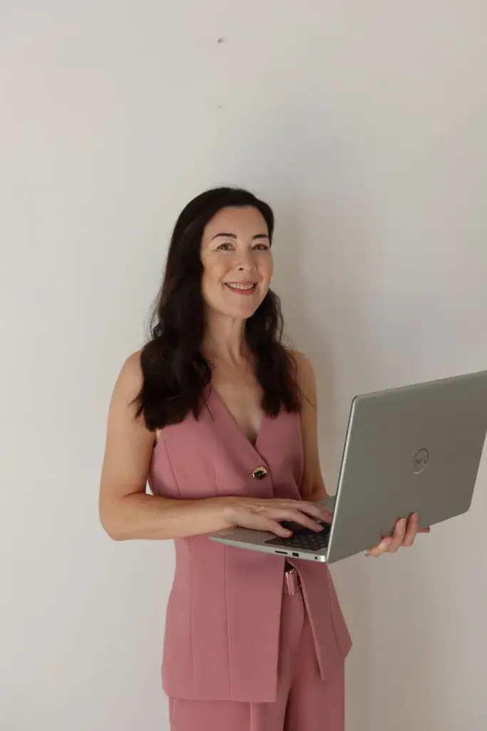 Tracy smiling, holding her laptop